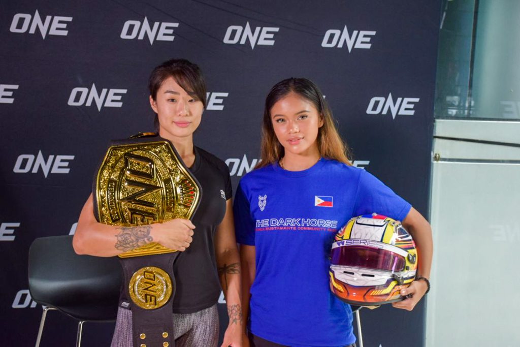 Bianca Bustamante exchanges gloves with Angela Lee in Singapore